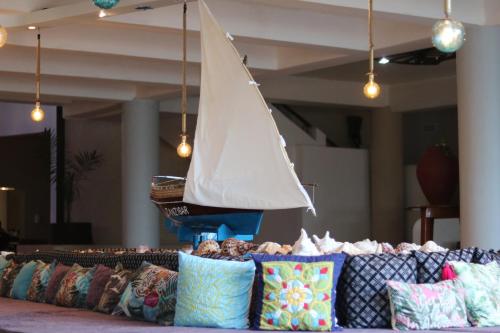 a sail boat on a table with pillows at Essque Zalu Zanzibar in Nungwi