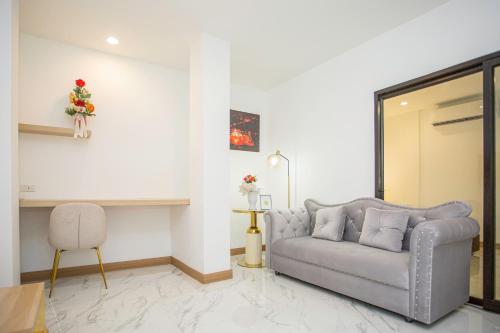 a living room with a couch and a table at One Sakon Nakhon Hotel in Ban Na Weng