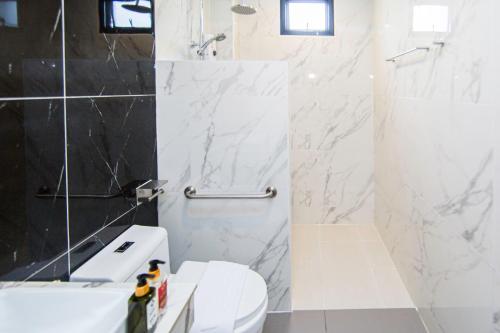 a white bathroom with a toilet and a shower at One Sakon Nakhon Hotel in Ban Na Weng