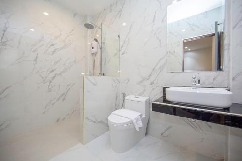a bathroom with a white toilet and a sink at One Sakon Nakhon Hotel in Ban Na Weng