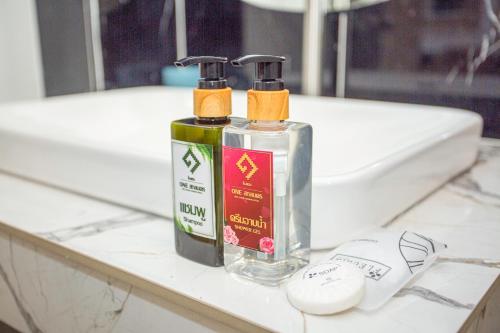 two bottles ofodorizers sitting on a bathroom counter at One Sakon Nakhon Hotel in Ban Na Weng