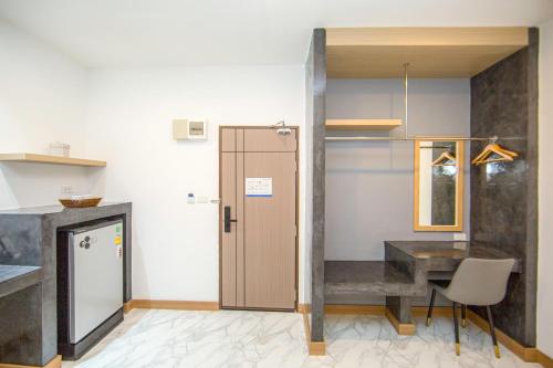 a kitchen with a desk and a table in a room at One Sakon Nakhon Hotel in Ban Na Weng