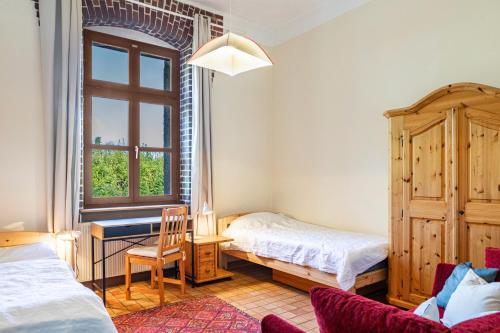a bedroom with two beds and a desk and a window at Ferienwohnung Zum Alten Hengststall in Herleshausen