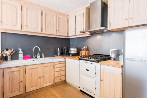a kitchen with white appliances and wooden cabinets at Chalet à Megève-Vauvray - Grands Appartements , vue Mont Blanc in Demi-Quartier