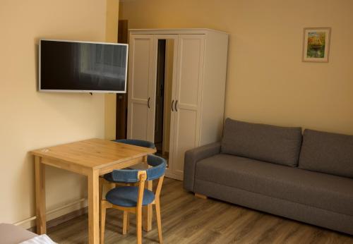a small living room with a table and a couch at Petöfi Vendégház in Eger