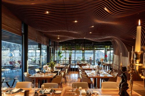 a restaurant with tables and chairs and a large window at Manna Resort in Montagna