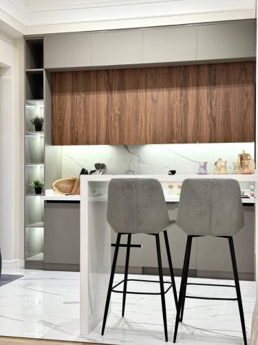 a kitchen with two chairs at a kitchen counter at Luxury apartment in Tashkent city in Tashkent