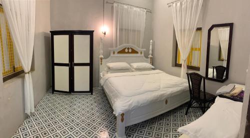 a bedroom with a white bed and a mirror at Arau Heritage Home in Arau