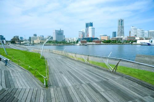 a bridge over a river with a city in the background at Sotetsu Hotels The Splaisir Yokohama in Yokohama