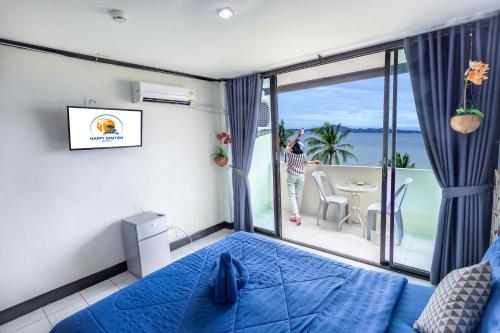 a bedroom with a blue bed and a balcony at Happy Jomtien - Direct Beach Access, Sea View & Central Location in Jomtien Beach