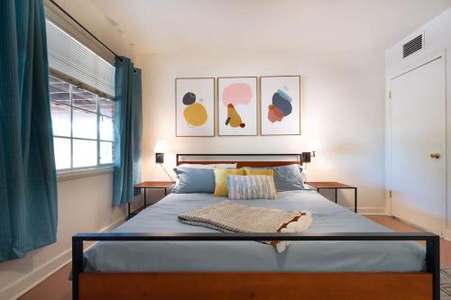 a bedroom with a bed with blue sheets and a window at Cali 2BR Getaway Firepit, Yard & Spring Charm in Tucson