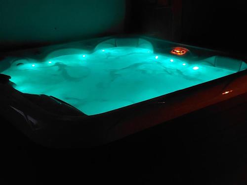 a hot tub with lights in a dark room at gîtes gorevirat in Corcelles