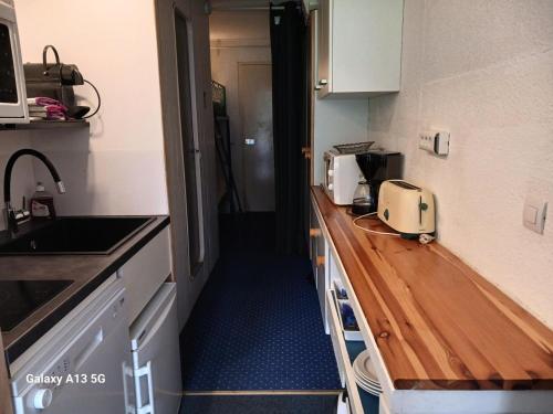 une cuisine avec un comptoir avec un évier et un micro-ondes dans l'établissement Résidence Belles Challes - Studio 4 personnes à Arc 1800 skis aux pieds et proche des commerces dans le village du Charvet MAE-4751, à Arc 1800