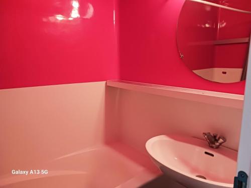 La salle de bains rouge est pourvue d'un lavabo et d'un miroir. dans l'établissement Résidence Belles Challes - Studio 4 personnes à Arc 1800 skis aux pieds et proche des commerces dans le village du Charvet MAE-4751, à Arc 1800
