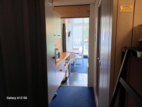 un couloir menant à une cuisine avec salle à manger dans l'établissement Résidence Belles Challes - Studio 4 personnes à Arc 1800 skis aux pieds et proche des commerces dans le village du Charvet MAE-4751, à Arc 1800