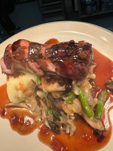 a white plate of food with meat and vegetables at The Ship Inn - Winner Best Hotel Experience 2024 Visit Scotland in Gatehouse of Fleet