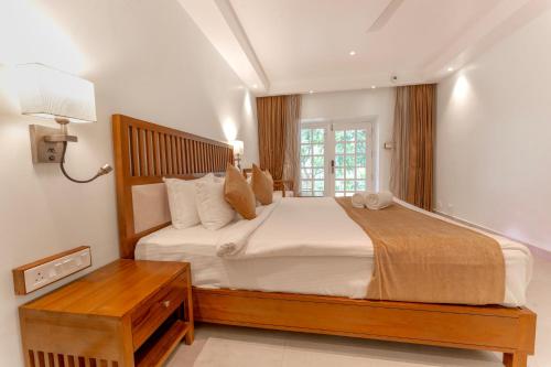 a bedroom with a large bed and a window at Le Montfort Resort in Munnar