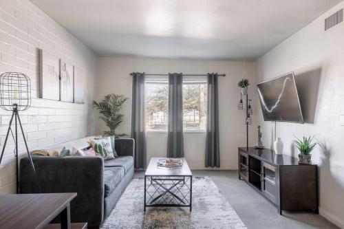 a living room with a couch and a table at 2BR 6 Min to UofA BBQ, Sunshine & Cozy Vibes! in Tucson
