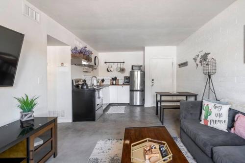 a living room with a couch and a kitchen at 2BR 6 Min to UofA BBQ, Sunshine & Cozy Vibes! in Tucson