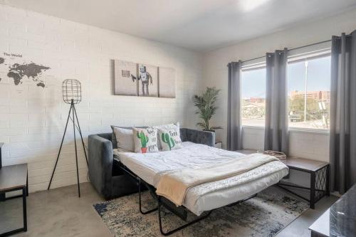 a bedroom with a bed and a large window at 2BR 6 Min to UofA BBQ, Sunshine & Cozy Vibes! in Tucson