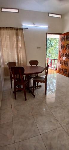 a dining room with a wooden table and chairs at ST Apartment in Kovalam