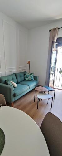 a living room with a green couch and a table at Casa Yaye Puerta Palma - Écija in Écija