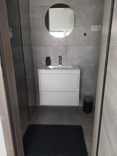 a small bathroom with a sink and a mirror at Tópart Apartmanok in Nagylengyel