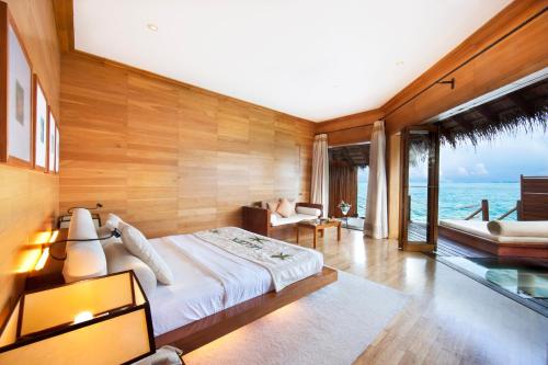 a bedroom with a bed and a view of the ocean at Adaaran Prestige Water Villas - with Dine around Premium All inclusive - 24 hours in Raa Atoll