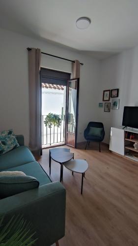 a living room with a green couch and two tables at Casa Yaye Puerta Palma - Écija in Écija