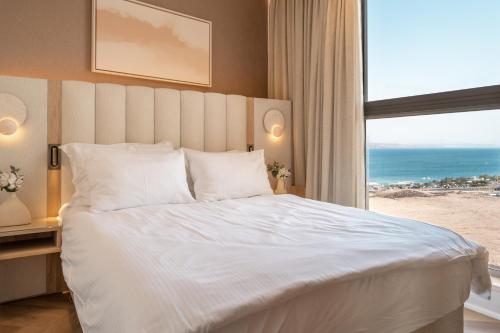 a bedroom with a large bed with a view of the beach at Queen Anne - Penthouse apartment with private pool in Eilat