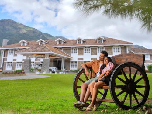 a man and a woman sitting on a wooden wagon at Le Montfort Resort in Munnar