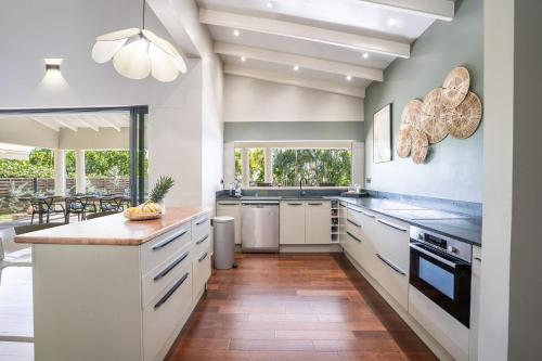 una cucina con mobili bianchi e una grande finestra di Villa Cactus a Le François