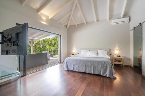 Un dormitorio con una cama y una puerta corrediza de vidrio. en Villa Cactus, en Le François