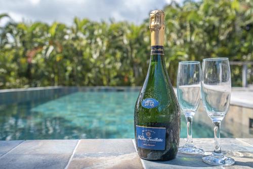 une bouteille de vin et deux verres à vin sur une table dans l'établissement Villa Cactus, au François