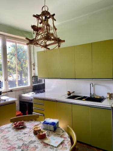 a kitchen with green cabinets and a table and a chandelier at Vanadzor Family Art House in Vanadzor