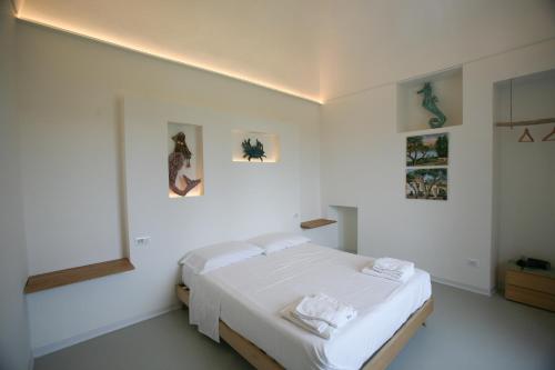 a bedroom with a bed in a white room at Il Carrubo in Procida