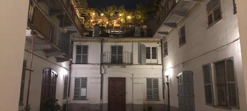 a white building with a door and a balcony with lights at Albergo Avalon in Turin
