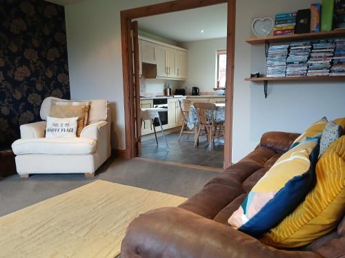 a living room with a couch and a kitchen at Holiday House Kinveachy in Aviemore