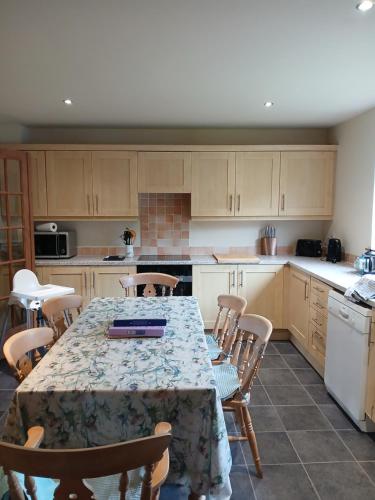 a kitchen with a table with chairs and a counter top at Holiday House Kinveachy in Aviemore