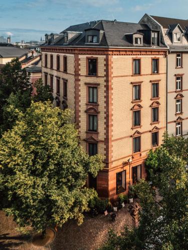 an apartment building with a tree in front of it at Libertine Lindenberg in Frankfurt/Main