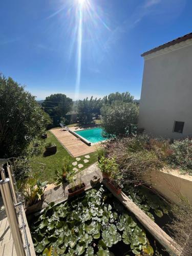 une arrière-cour avec une piscine et beaucoup de plantes dans l'établissement Au fil de soi, à Saint-Julien-de-Peyrolas