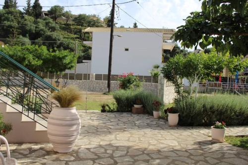 a patio with a large white vase with plants in it at Fissas Rooms in Sivota