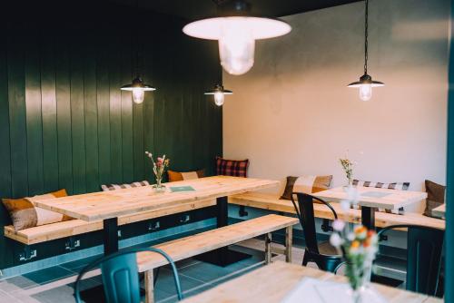 a dining room with wooden tables and chairs at Tiny Houses & Schwedenhäuser Ahoi Camp Canow in Wustrow