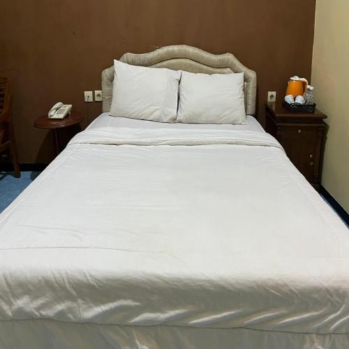 Postel nebo postele na pokoji v ubytování Wonorejo Hotel Mitra RedDoorz