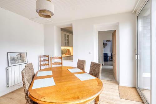 une salle à manger avec une table et des chaises en bois dans l'établissement Les Brises Normandes - Maison à 4min de la plage, à Saint-Pierre-en-Port