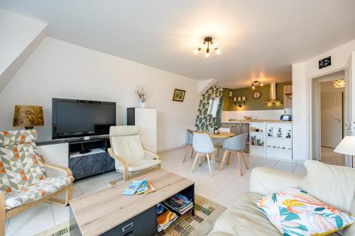 un salon avec un canapé et une télévision dans l'établissement Magnolia Bleu - Appt 61 m2 pour 4 avec parking, à Plouha