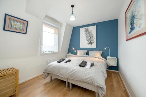 - une chambre dotée d'un lit avec un mur bleu dans l'établissement Magnolia Bleu - Appt 61 m2 pour 4 avec parking, à Plouha