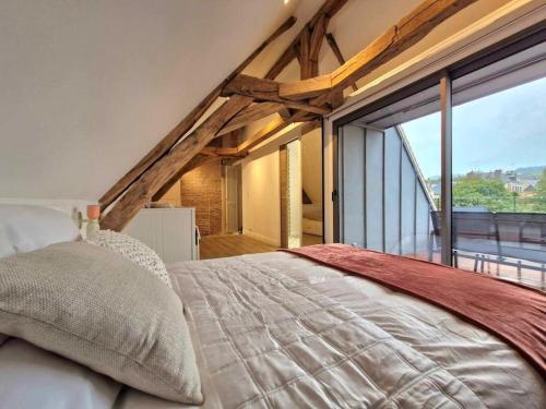 une chambre avec un lit et une grande fenêtre dans l'établissement Belle de Nuit, à Saint-Satur