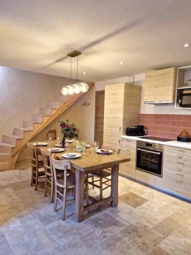 une cuisine avec une table et des chaises ainsi qu'un escalier dans l'établissement Belle de Nuit, à Saint-Satur