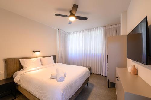 a bedroom with a bed and a flat screen tv at Rokah Luxury Villa at Ramat HaHayal in Tel Aviv